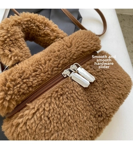 Detail of smooth silver dual zippers and soft brown faux shearling texture on handbag