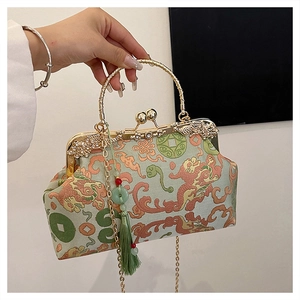 Detailed shot of Chinese embroidery bag with jade tassel and gold engraved clasp