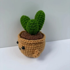 Detailed macro view of a handmade crochet succulent plant in a cute smiling pot