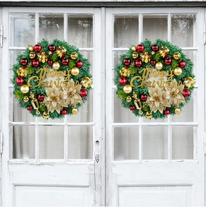 Close-up of artificial green Christmas wreaths with red and gold ornaments on a white door
