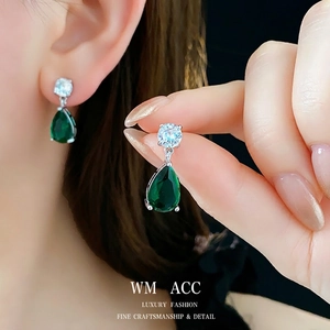 Elegant silver earrings with pear-cut emerald green stones and round zircons on model