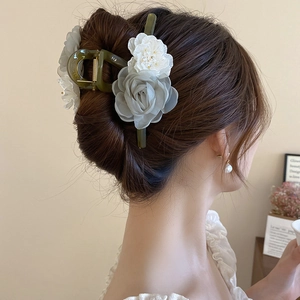 Dettaglio della pinza per capelli con rose in organza e fiori in acrilico su base oliva