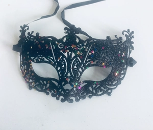 Detail of a black cutout masquerade mask with colorful star sequins and black ribbons