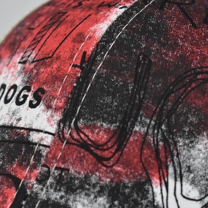 Close-up of red and black tie-dye cotton baseball cap with DOGS letter embroidery
