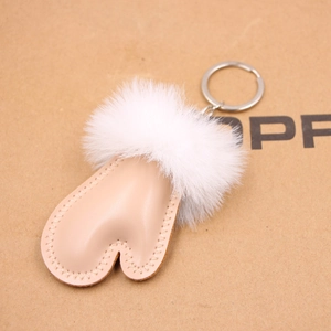 Close-up of heart-shaped nude leather pendant with fluffy white fur pompom keychain