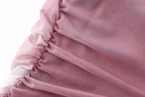Close-up of pink mesh fabric texture with white pleated trim on a spring dress