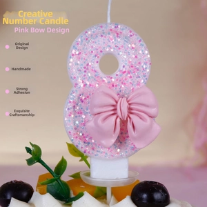 Detailed view of pink glitter number 8 candle with a bow on top for birthday cakes