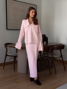 Detail of pink knit set featuring flared sleeves and button-up cardigan texture