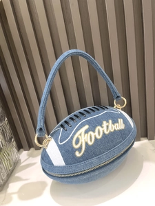 Detailed macro view of denim rugby ball handbag featuring gold Football embroidery