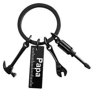 Close-up of black keychain with Papa engraving and miniature hammer and wrench tools