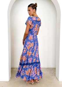 Detail of floral printed maxi dress featuring high waist and blue lace patchwork hemline