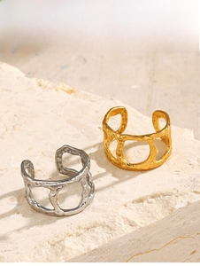 Close-up of gold and silver hammered hollow rings on a textured stone display