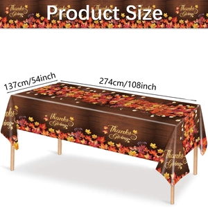 Detail view of Thanksgiving tablecloth with maple leaves and golden Thanks Giving text