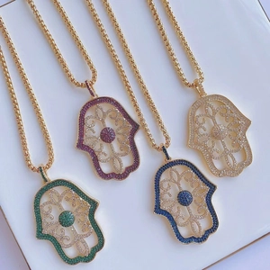 Detail of Hamsa Hand pendants featuring colorful micro-pave zircons on gold chains