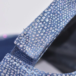 Macro shot of navy denim baseball cap strap with silver rhinestones and neat stitching