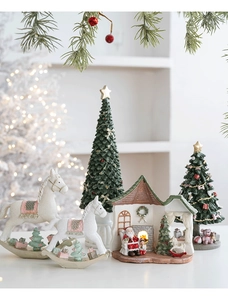 Festive resin Santa cottage with rocking horse and mini Christmas tree tabletop decor