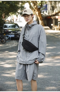 Detail of a casual black crossbody bag styled with a grey urban outdoor outfit