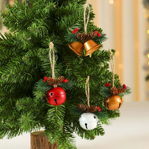 Close-up of Christmas bells with pine cones and red berries hanging on a pine tree branch