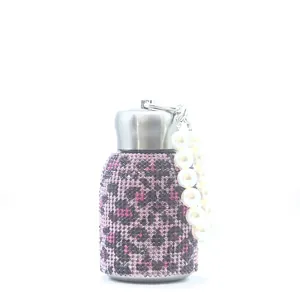 Close-up of 300ml leopard print rhinestone insulated bottle with a pearl handle strap