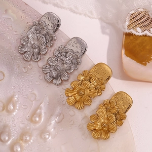 Detail view of retro triple flower studs in gold and silver finish with metallic texture