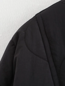 Detailed close-up of stitching and fabric texture on a black quilted casual jacket