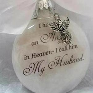 Close-up of frosted white memorial ornament with angel charm for beloved husband