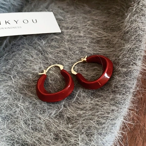 Détail des boucles d'oreilles en U avec plaquage or 14K et finition émaillée rouge foncé