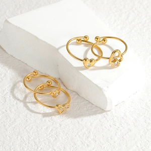 Detail view of heart-shaped gold rings with cubic zirconia on white stone