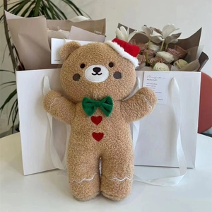 Detail of gingerbread plush bear with a red Christmas hat and green bowtie