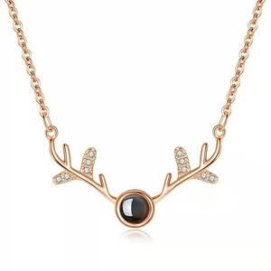 Detail of rose gold reindeer antler pendant with black projection stone and zircon accents