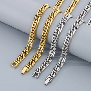Detail view of silver and gold Cuban link chains with secure box clasp closure