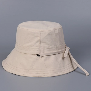 Détail du chapeau de soleil beige en nylon avec coutures zigzag et ouverture pour queue
