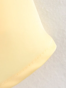 Détail de la texture en soie jaune et des coutures de précision sur le top dos nu