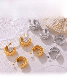 Detailed macro view of PVD electroplated gold and silver textured C-shaped stud earrings