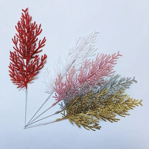 Sparkly artificial Christmas pine branches with glitter finish in red gold and silver colors