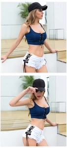 Dettaglio del top corto denim blu e pantaloncini bianchi con lacci laterali sexy