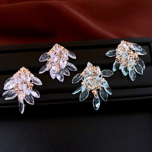 Close-up of elegant rhombus tassel earrings with marquise-cut white and blue crystals