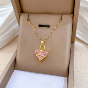 Détail du collier coeur rose avec lettre A dorée et cadenas sur boîte à bijoux