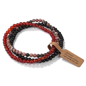 Detail of 4mm natural stone beaded stretch bracelets in black and red with paper tag