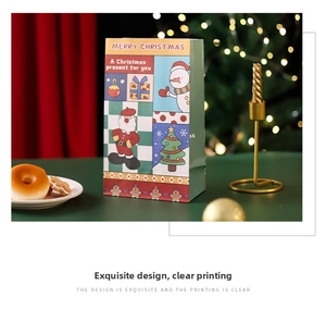 Detailed view of a festive Christmas paper gift bag with cartoon Santa and snowman patterns