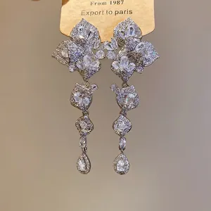 Sparkling zircon tassel earrings with flower and water drop pendant on a display card