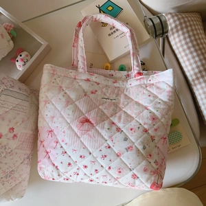 Close-up of quilted floral tote bag with heart patterns and simple wish label