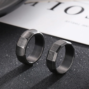 Macro detail of dark matte titanium rings with geometric industrial faceted edges