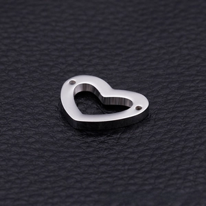 Macro detail of silver stainless steel heart pendant with dual side holes on leather