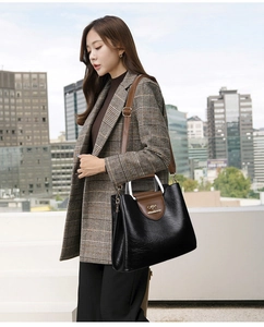 Detail of black and brown PU leather tote with golden kangaroo logo and textured finish