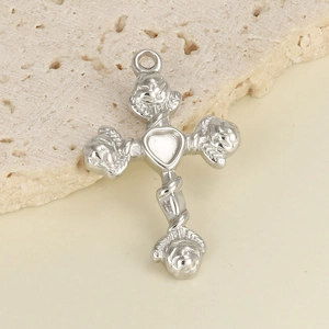 Macro detail of a 304 stainless steel heart cross pendant with angel heads on stone