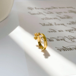 Macro shot of 18K gold ring featuring three claw-set zircon stones with elegant lighting