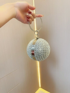 Detailed view of silver sphere evening bag with sparkling rhinestones and metal ring handle