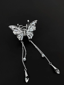 Close-up of silver butterfly hair claw clip with zircon stones and long chain tassels