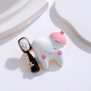 Close-up of a cute tooth brooch with pink hat and Kaonashi toothbrush detail